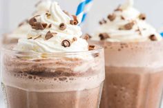 two glasses filled with chocolate milkshakes and whipped cream