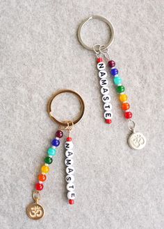 two key chains that have different colored beads on them, one with an ombrella and the other with a peace sign