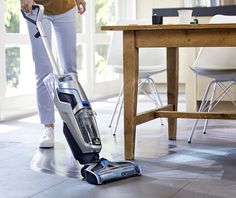 a woman using a vacuum cleaner on the floor