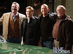 four men standing next to each other in front of a green car with the words blue bloods written on it