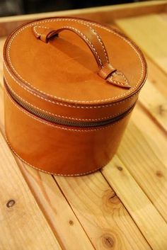 a brown leather case sitting on top of a wooden table