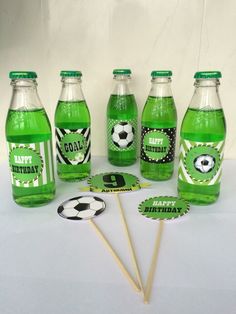 a group of green soda bottles sitting next to each other on top of a table