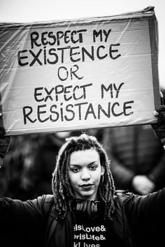 a person holding up a sign that says respect my existence or expect my resistance