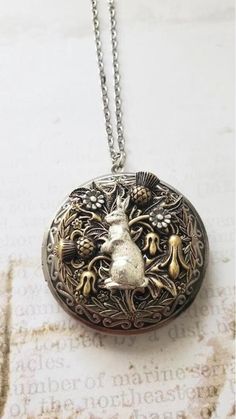 Rabbit Locket Wanderlust Necklace  Beautifully detailed Locket with cute little bunny against nature scene. Can be used to store your treasured photo or as small a pill box.  ☻ See Photos for size comparison against American quarter Chain: ~ Antique Silver  YOU CHOOSE YOUR CHAIN LENGTH during checkout ☻More Lockets Here: https://www.etsy.com/shop/FashionCrashJewelry/search?search_query=lockets&order=date_desc&view_type=gallery&ref=shop_search ☻Link to The ENTIRE SHOP: https://www.etsy.com/shop/FashionCrashJewelry?ref=shopsection_shophome_leftnav&ga_search_query=crystal%2Bnecklace Our Motto ~ Happy Customers Are Awesome Let us know of any problems or concerns with purchases. 5star reviews and positive comments are greatly appreciated, they help the success of our shop more than you know ♥ T Unique Locket Necklace, Wanderlust Necklace, Rabbit Necklace, Enchanting Forest, Wanderlust Jewelry, Vintage Jewlery, Jewelry Nature, Steampunk Accessories, Nature Necklace