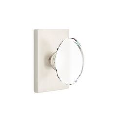 an oval mirror mounted to the side of a white wall mount door handle on a white background