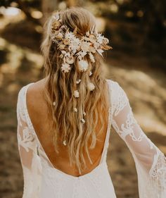 the back of a woman's head with long hair and flowers in her hair