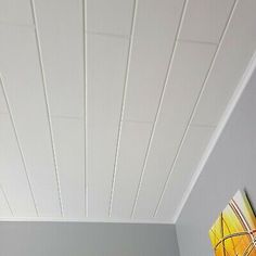 a bedroom with white painted ceilings and a painting on the wall