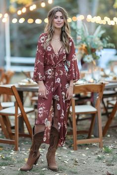 a woman standing in front of a table wearing cowboy boots and a floral print dress