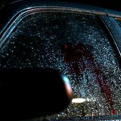 a car that is covered in rain and red liquid