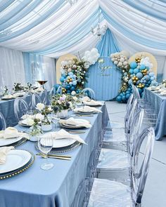 a table set up for a party with blue and white decorations