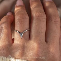 a woman's hand with a silver ring on top of her left hand and the middle finger