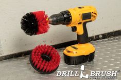 a drill and brush sitting next to each other on the floor in front of a wall