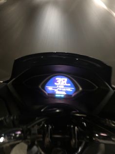 a close up view of the front wheel of a motorcycle with its lights on at night