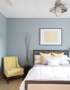 a bed sitting in a bedroom next to a yellow chair