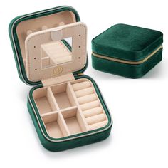 an open green velvet jewelry box with compartments and dividers on the inside, sitting next to a small case