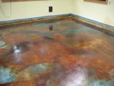 a room that has been painted with different colors and patterns on the floor, including rusted paint