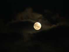 the moon is shining brightly in the dark night sky with some clouds and black skies