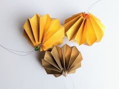 two yellow origami fans on white background with string attached to the top one