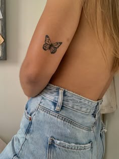 a woman with a butterfly tattoo on her upper arm and lower half of her body