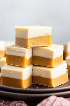 several pieces of white chocolate stacked on top of each other in front of a plate