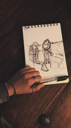 a person holding a notebook with a drawing on it