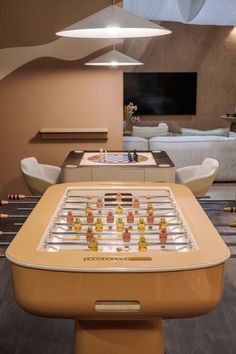 an old fashioned foosball table is in the middle of a room with chairs and couches