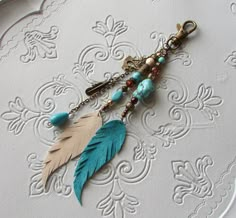 a close up of a key chain with beads and feathers hanging from it's end