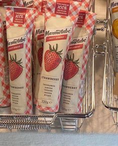 several packets of strawberry milk are on display in a grocery store's produce section