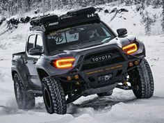 a toyota truck driving through the snow on its way to an unknown location in the woods