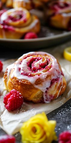 raspberry cinnamon rolls with icing and fresh raspberries on the side