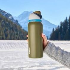 a person holding a water bottle in the snow