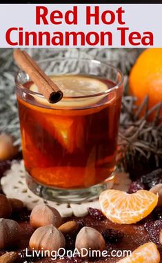 red hot cinnamon tea in a glass mug surrounded by nuts and oranges