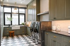 a kitchen with green cabinets and checkered flooring