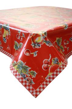 a red and white table cloth with floral designs on the top, sitting on an isolated surface