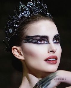 a woman with black makeup wearing a tiara