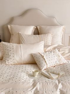 a white bed topped with lots of pillows