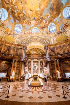 the interior of a large library with many bookshelves and paintings on the ceiling