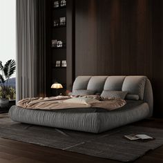 a large bed sitting on top of a hard wood floor next to a tall window