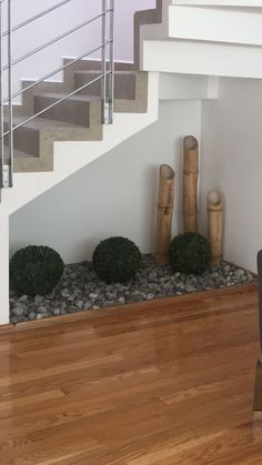 there is a chair and some rocks in front of the stair case on the wooden floor