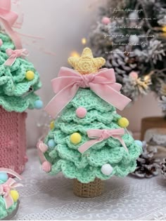 two crocheted christmas trees sitting next to each other