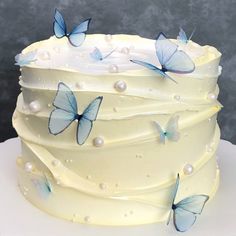 there is a white cake with blue butterflies on it