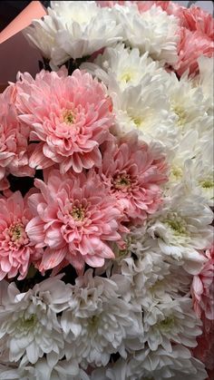 a bunch of pink and white flowers sitting on top of each other