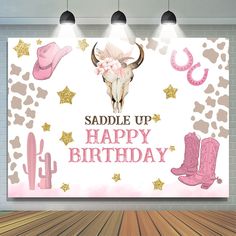 a happy birthday banner with cow skulls, boots and flowers on the wall in front of a brick wall