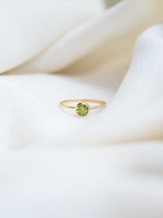 P E R I D O T ∙ R I N G  This ring features a dazzling round-cut peridot gemstone at its center. This stunning piece showcases a unique zircon design on one side of its band, adding a touch of brilliance and sophistication. Crafted from 24k gold vermeil over 925 sterling silver, it offers a luxurious look and feel while ensuring durability.  This ring is also available in Blue Topaz, Garnet, Amethyst, Citrine, Carnelian and Iolite Gemstone. Please write to us for customisations.  * Material: High Quality 24K Gold Vermeil on 925 Sterling Silver - Waterproof, Hypo-Allergenic and Nickel Free * Finish: 24K Gold Vermeil on 925 Sterling Silver | Also available in solid 925 Sterling Silver * Featuring a 5 MM Round Peridot and 9 pieces of 1 MM Round Cubic Zircon Gemstones. * Total Stone Weight: 0. Handcrafted Silver Jewelry, August Birthstone, Natural Stone Jewelry, Peridot Ring, Peridot Gemstone, August Birth Stone, Green Gemstones, Elegant Jewelry, Solid 925 Sterling Silver