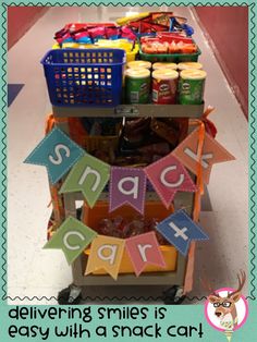 a shopping cart filled with snacks and candy sitting on top of a store floor next to a sign that says, delivering smiles is easy with a snack car