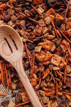 a wooden spoon sitting on top of a pile of cheetos and crackers