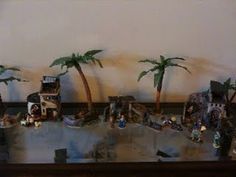 there are many figurines on the table with palm trees in front of them