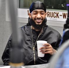 a man with a beard holding a coffee cup