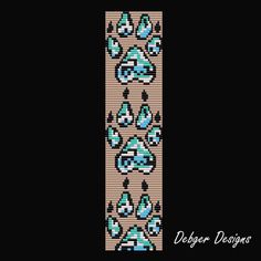 a cross stitch bookmark with blue flowers and leaves on it, against a black background