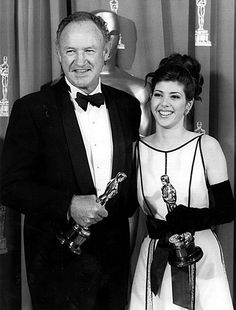 an old black and white photo of two people holding their oscars in front of them